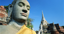 Buddha-szobor háttérben egy templommal